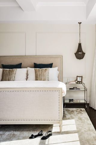 Cream bedroom with grey linen bed and black pendant lighting