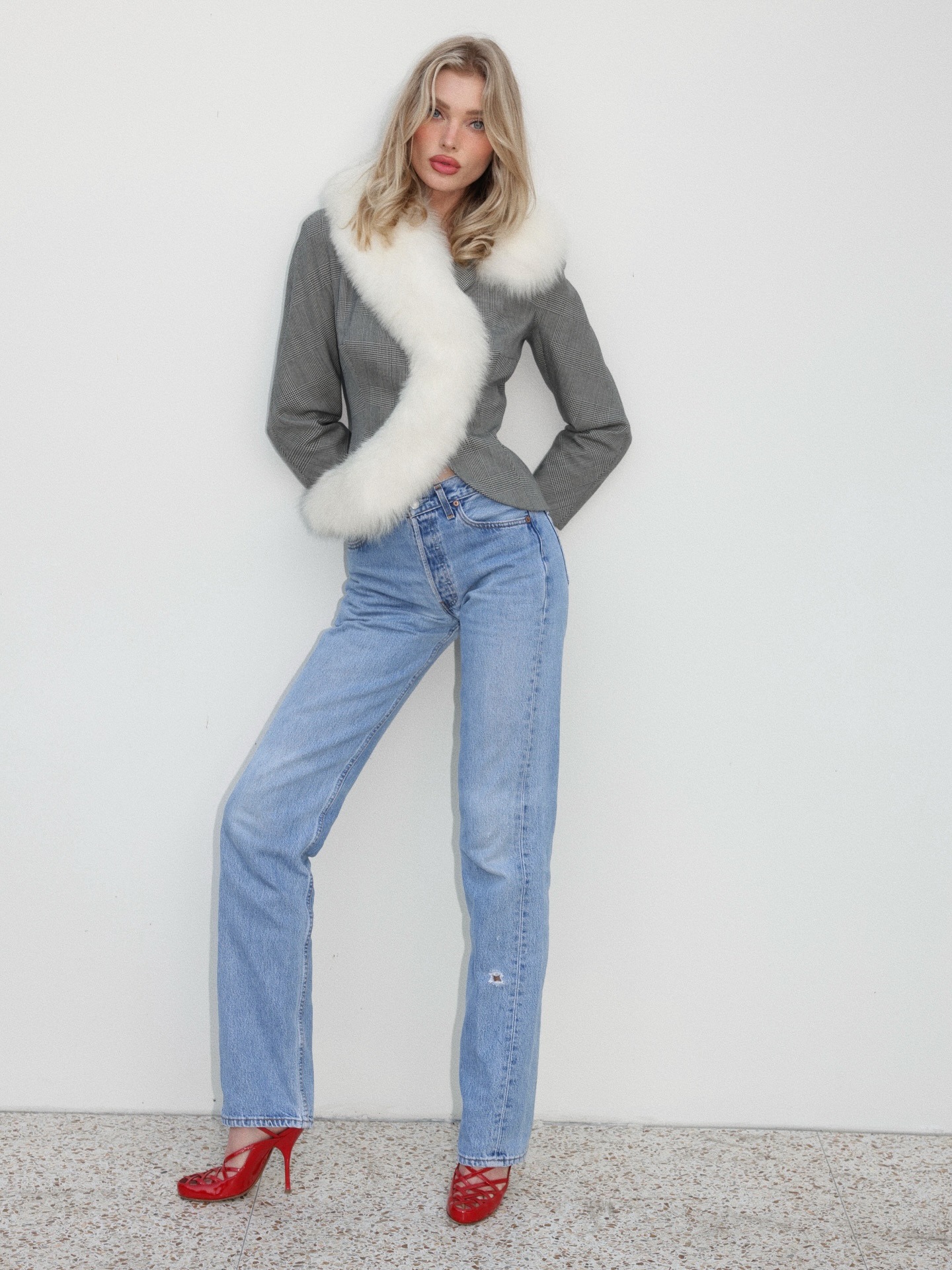 Elsa Hosk wearing a gray Dior blazer, light-wash jeans, and red heels