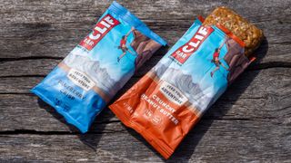 A pair of clif energy bars on a wooden bench