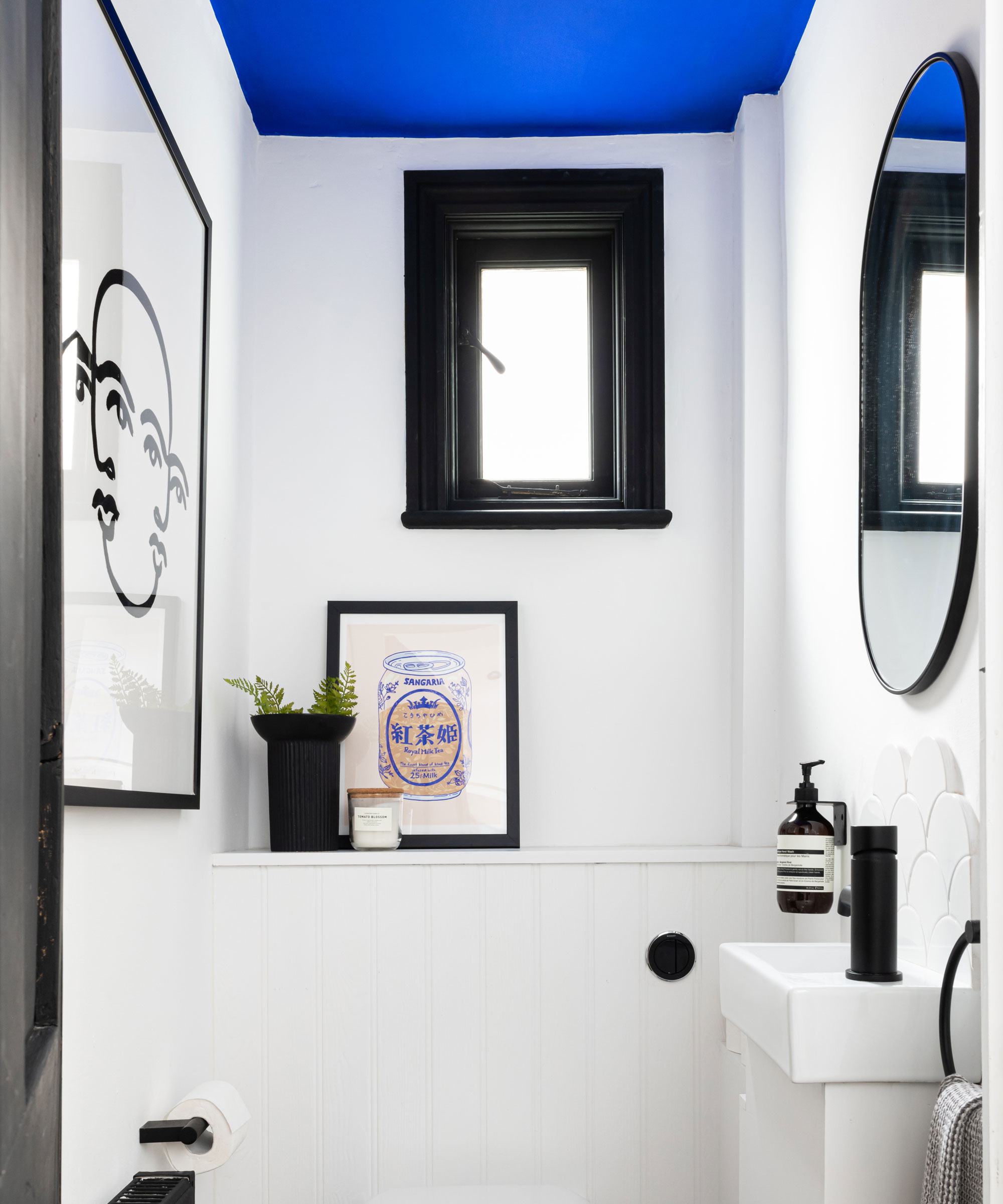 Small WC with bright blue ceiling feature and mono fixtures and styling accents