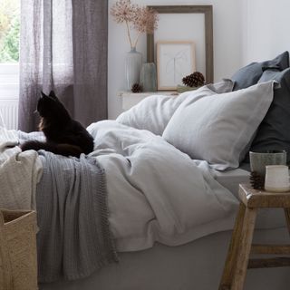 bedroom with black cat and bed with pillows
