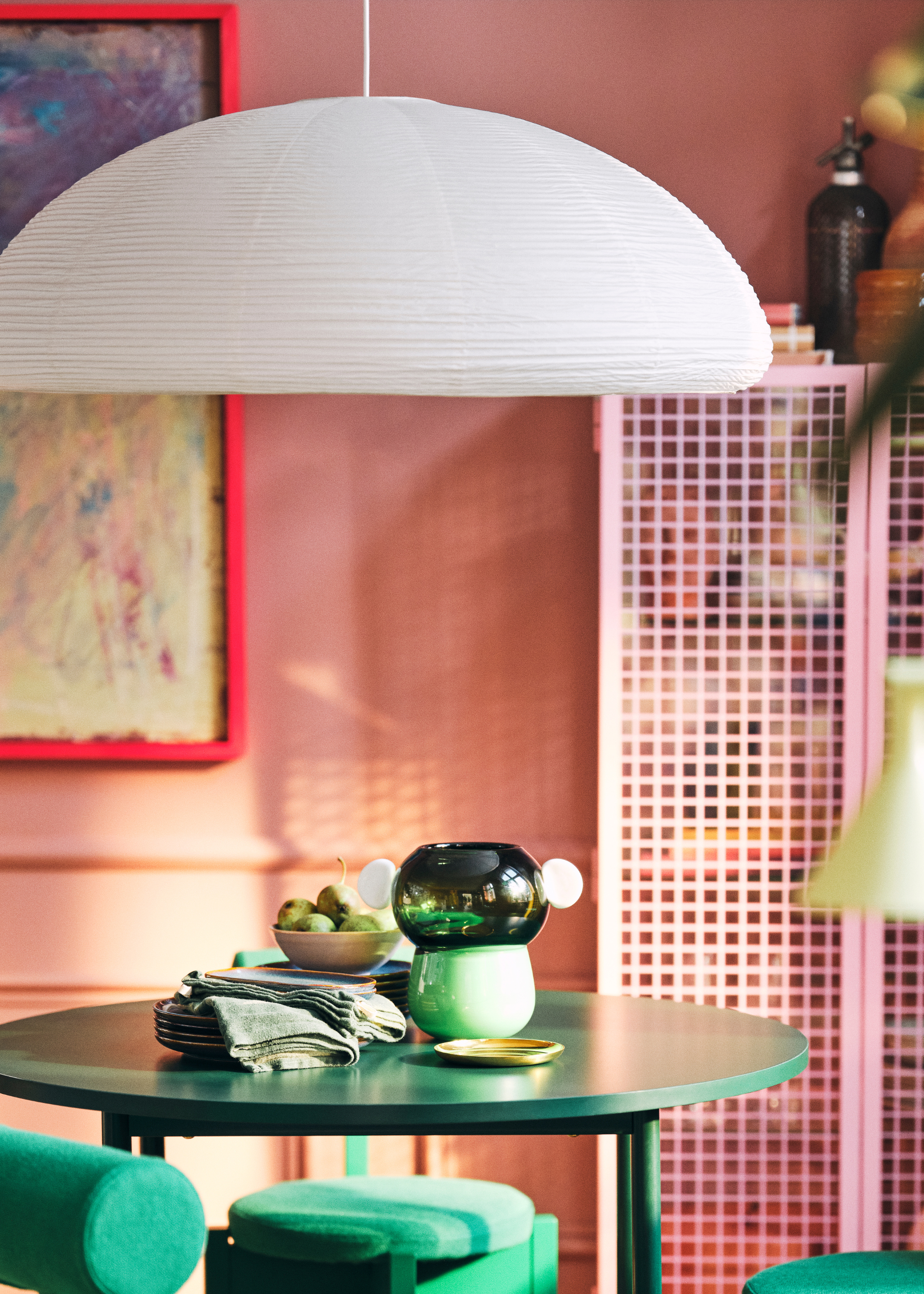 IKEA PS collection rice dome lamp hangs over a green table with green glass vase