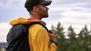 Man hiking with pine trees in the distance