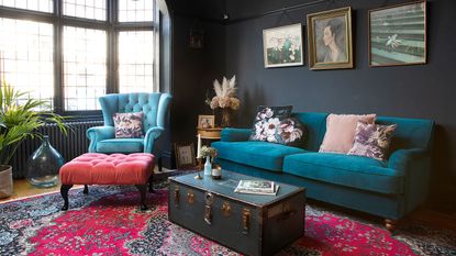A dark traditional living room with vintage trunk used as a coffee table alternative