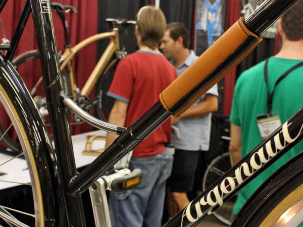 A polished stainless steel brace joins the top tube and seat tube while a leather protector prevents scratches when the bike is locked up.