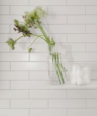 Shelf in shower with vase and flowers