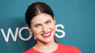 Alexandra Daddario smiling at the camera in a red dress at the AMC Networks 2025 Upfront in New York City.