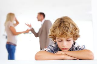 Child with parents arguing in background