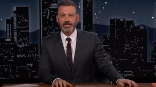 Jimmy Kimmel sitting at his desk during an introduction in Jimmy Kimmel Live.