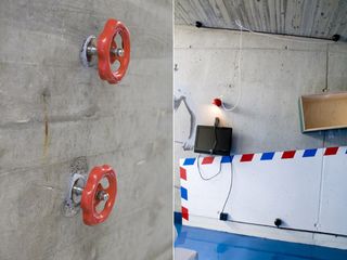 Left: two orange water pump controls on a concrete wall. Right; angular design painted on a wall beside a wall-mounted television