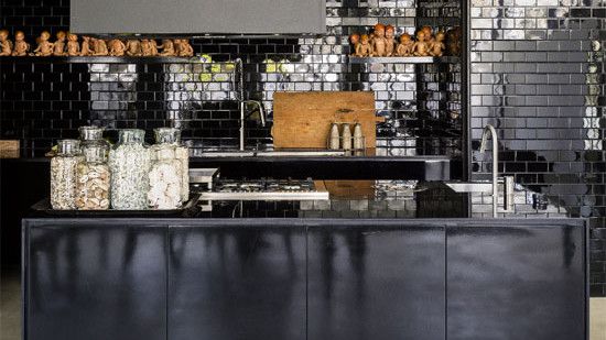 kitchen area with black kitchen counter and black brick tiles wall