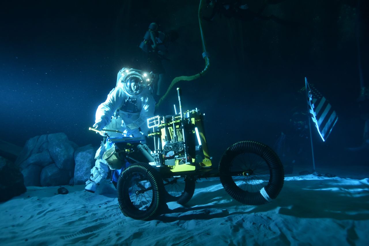 Experiments are ongoing to transform part of the Neutral Buoyancy Laboratory, a pool facility used by NASA for International Space Station spacewalks, into a practice zone for moonwalks. The underwater work is early-stage, but is working with prototypes of spacesuits and hardware, along with sand and landscape features like elevation.
