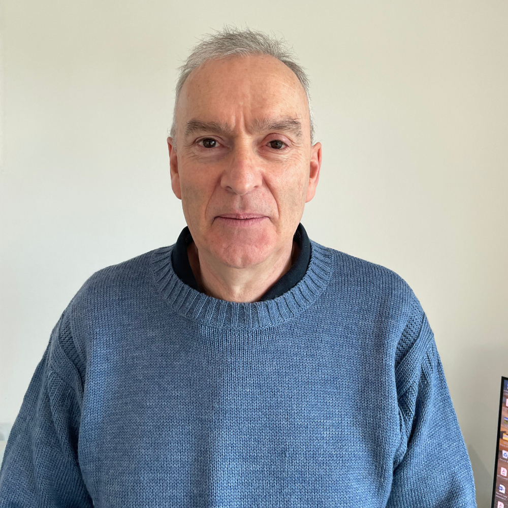 male with short grey hair wearing blue jumper