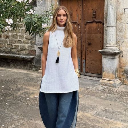 Rosie Huntington-Whiteley wears a stone necklace, white top, and barrel-leg jeans.