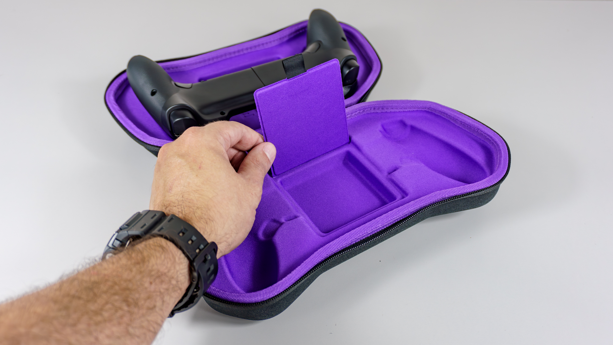 A person showing off the hidden storage compartment inside the case for the Elo Vagabond mobile game controller