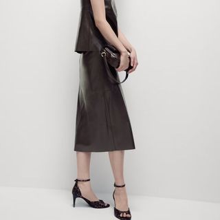 Flat lay image of a woman wearing a brown skirt and heels