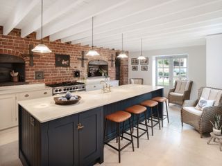 A kitchen with a large kitchen island and exposed brick wall