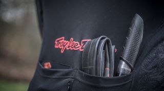 This is a close up image of the rear pockets of a rider, showing a pump and spare bike inner tube