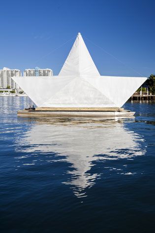 Made of bamboo poles, wires, and sails, the paper boat is illuminated like a beacon at night.