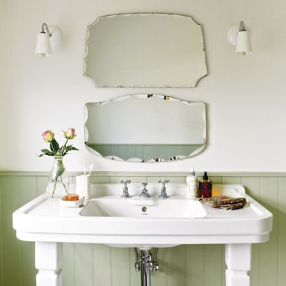 bathroom with mirror on white wall and white washbasin