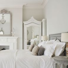 bedroom with cushions mirror and table lamp