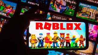 A smartphone with Roblox characters and logo on the screen