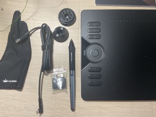 A photo of the Huion HS610 on a table with all its accessories
