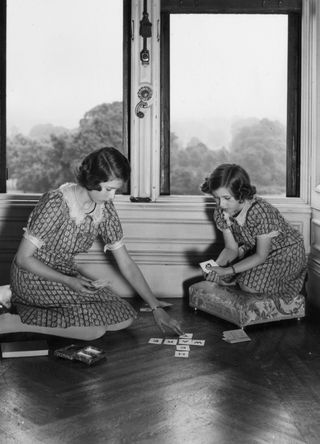 A young Queen Elizabeth and Princess Margaret playing a card game