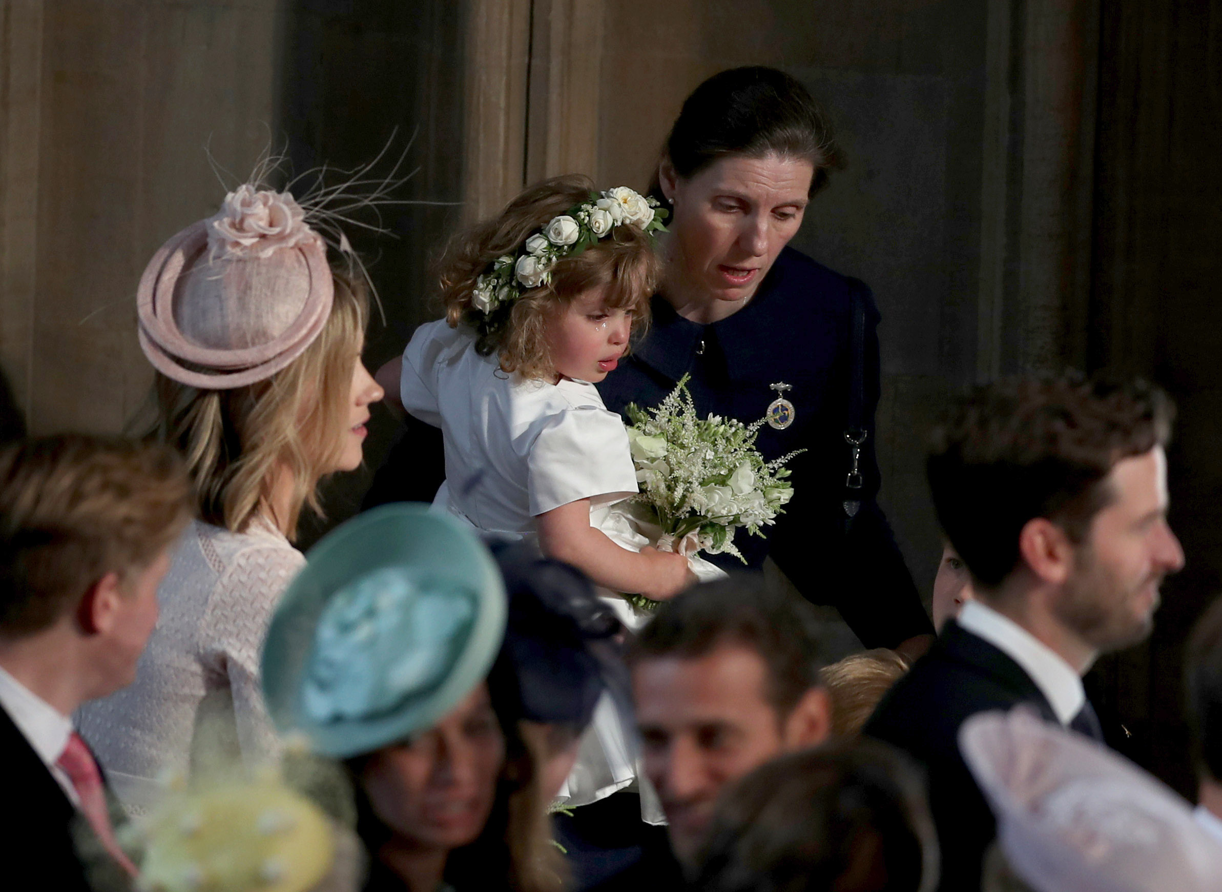 Nanny Maria holding a crying flower girl at Harry and Meghan's wedding