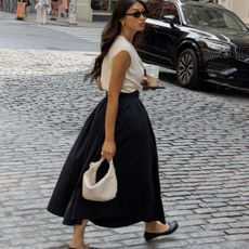 @michellelin.lin wears a black cotton skirt with a white top