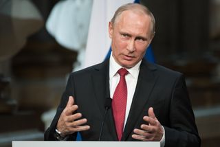 Vladimir Putin speaking at a podium