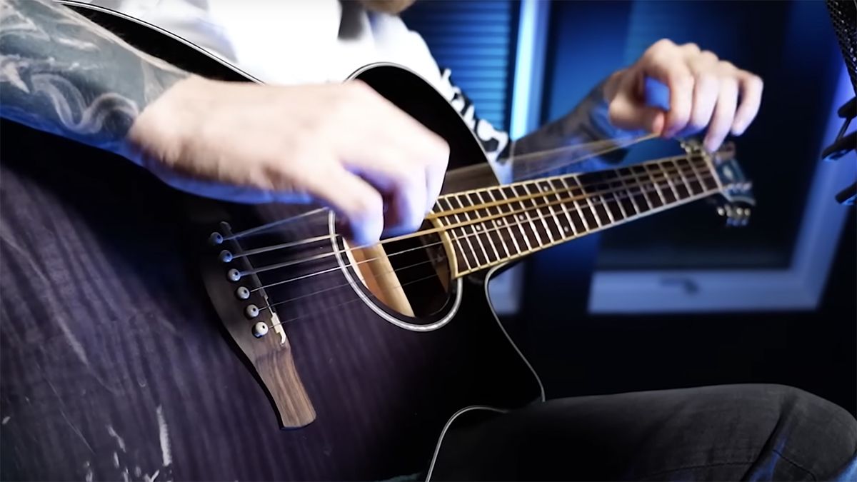 Bernth playing a rubber band-stringed acoustic guitar