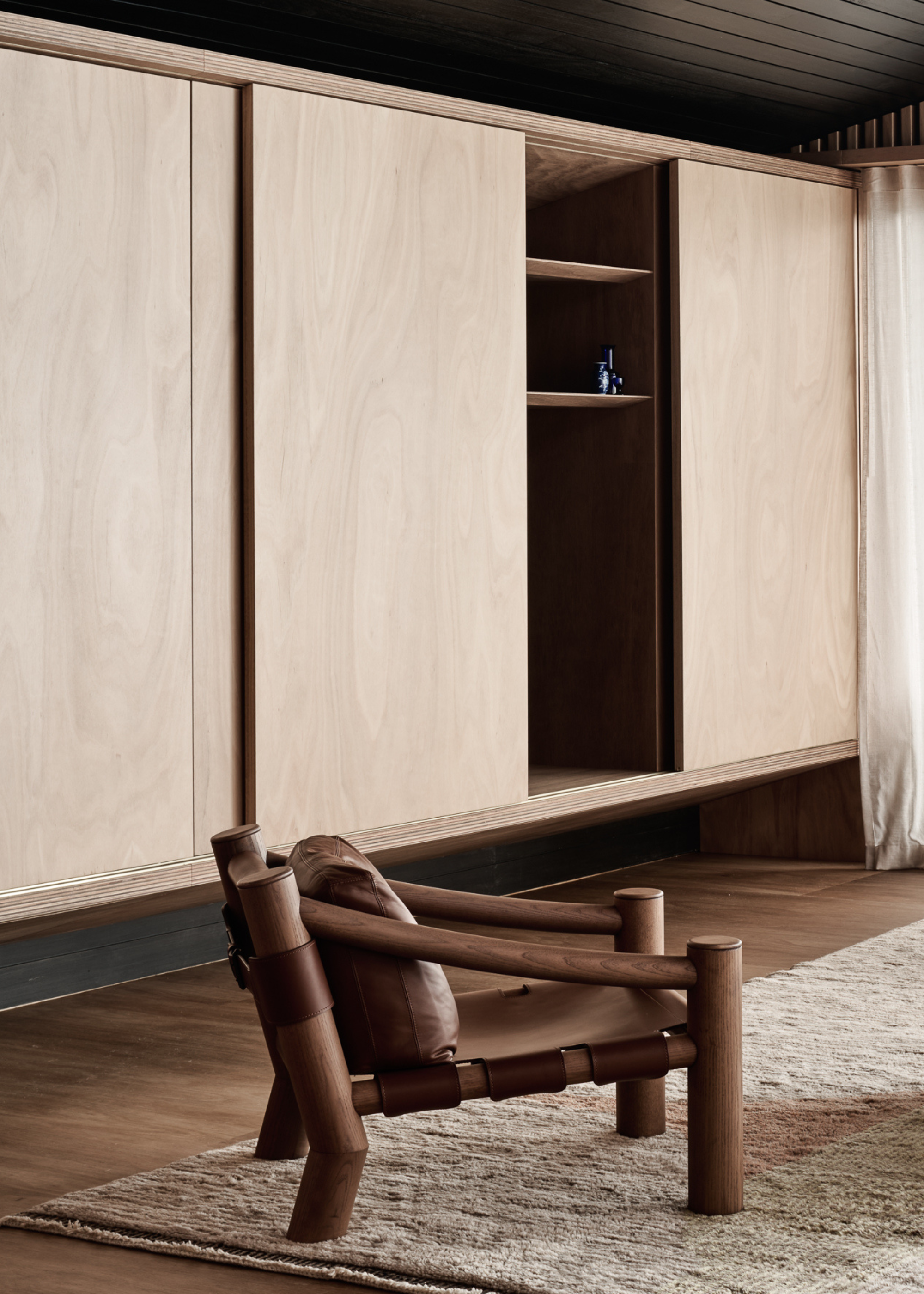 A wooden closet with a low-slung seater on a rug