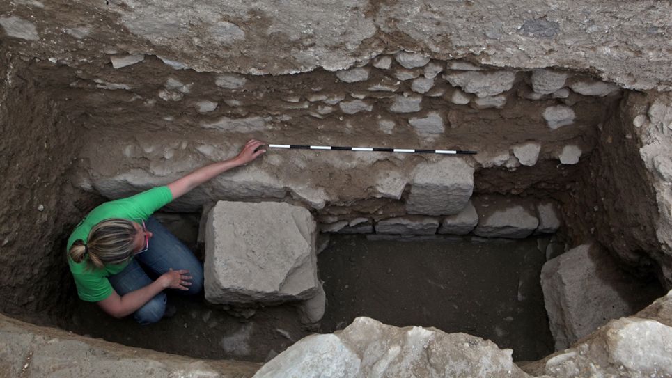 An archaeologist examines the foundation of the first mosque right above remains of a monumental Roman building.
