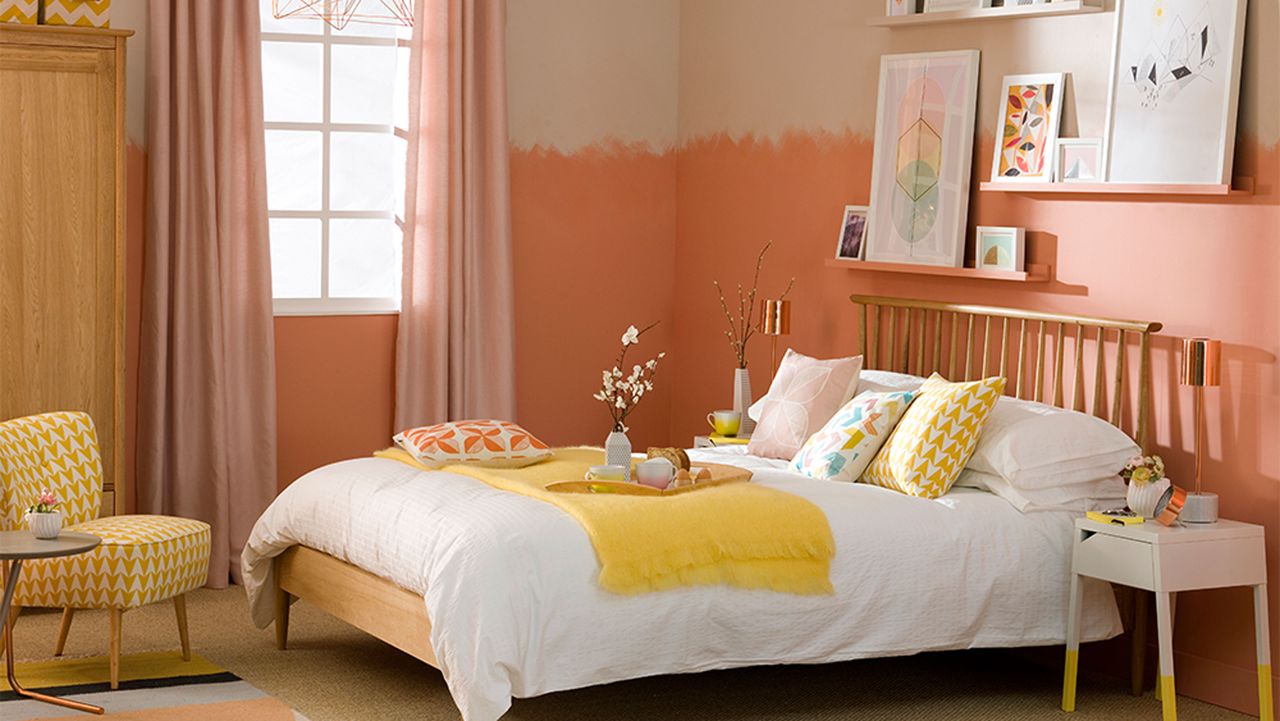 orange bedroom with two tone walls and picture display