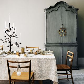 neutral dining room with festive table featuring large tree candle holder