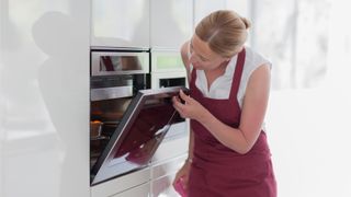 Woman holding an oven door open