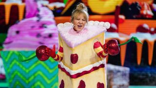 Lulu singing on stage dressed as a piece of cake in The Masked Singer UK 2023