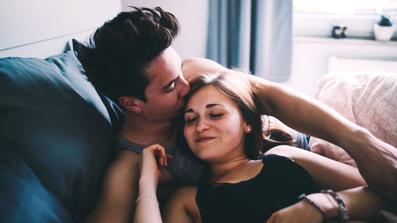 couple in bed cuddling and kissing