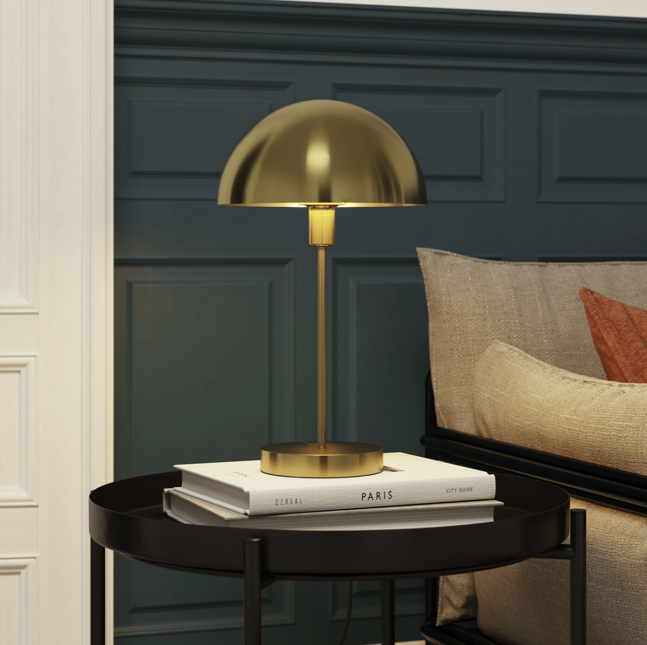 Gold lamp on top of a coffee tale book in front of a blue wall