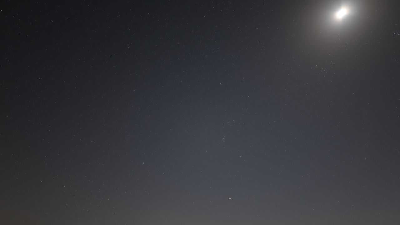 Orion and the moon in the starry night sky photographed with the Canon EOS R5 II and Canon RF 20mm f/1.4 L VCM lens.