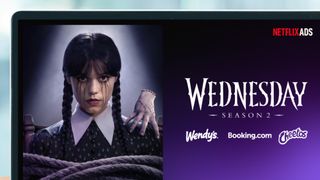 A laptop screen showing a Netflix ad for Wednesday Season 2