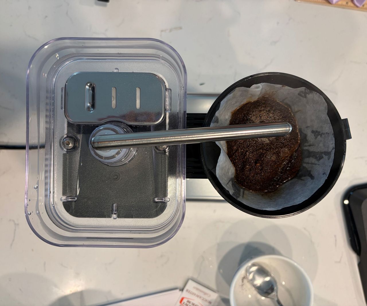 A Moccamaster Cup-One drip coffee maker viewed from above, with an open reservoir and filter cup.