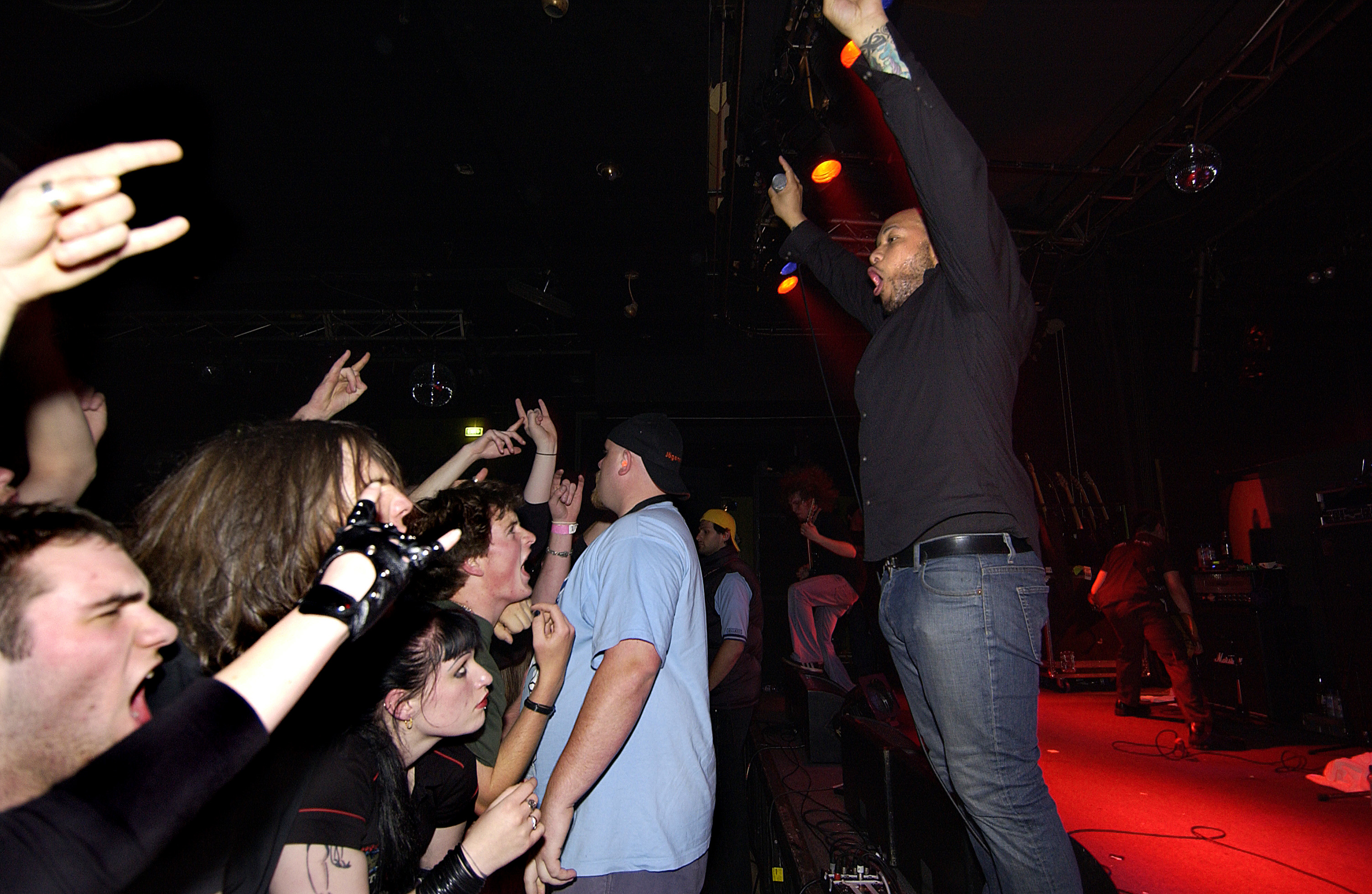Howard Jones with his arms raised on stage in 2004