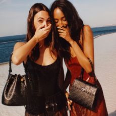 Two women carrying Tory Burch handbags