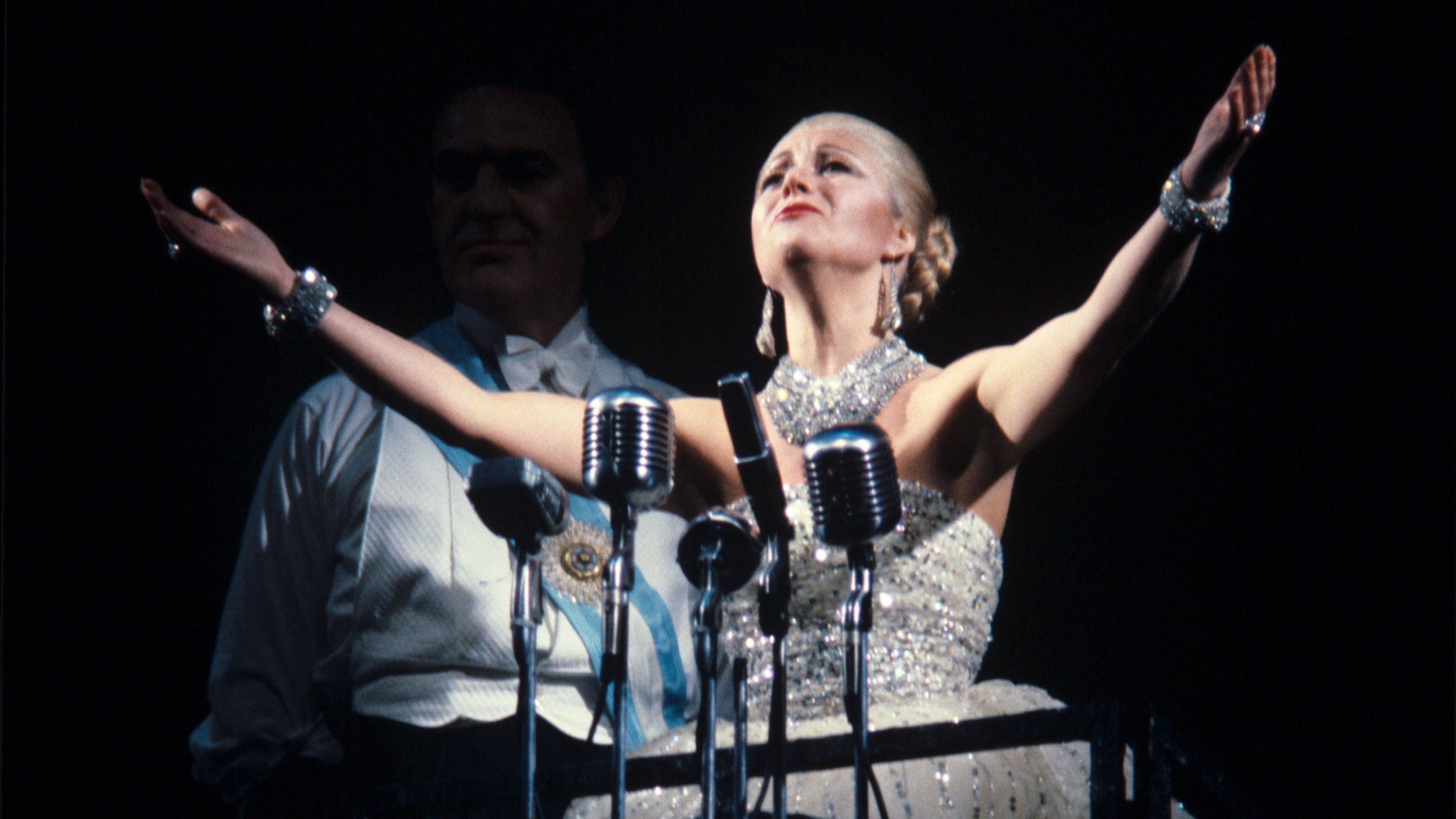Elaine Paige in a glittery dress with her arms in the air as Eva Perón in Evita