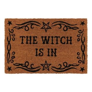 A Halloween dormat that says 'The witch is in'