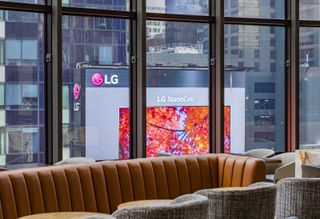 A view of an LG display with the LG logo through a hotel window.