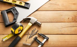 variety of carpentry tools on wood planks with copy space