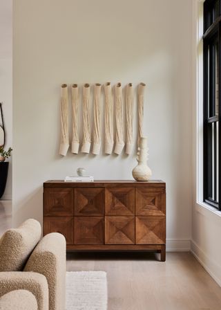 A living room with beige decor and a wood credenza